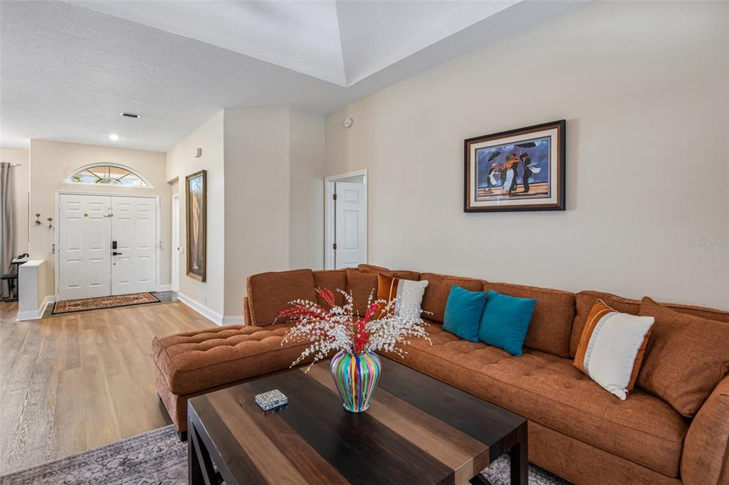 A living room features a large brown sectional sofa, a wooden coffee table, and light flooring — 14337 BRONTE COURT, HUDSON, FL
