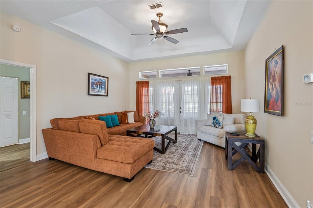 A living room features a brown sectional sofa, a coffee table, and a vaulted ceiling — 14337 BRONTE COURT, HUDSON, FL