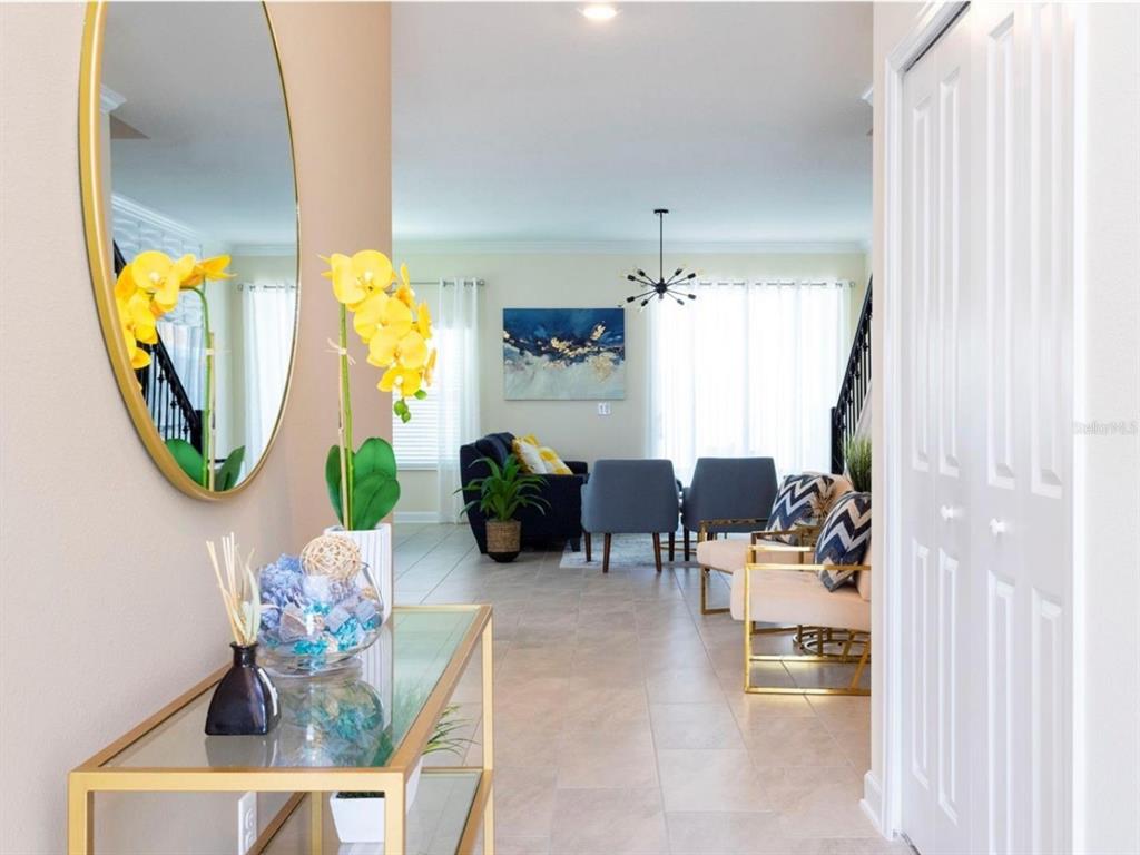 A view from a hallway into a living room with tile floors and gold accents — 1176 CHALLENGE DRIVE, DAVENPORT, FL