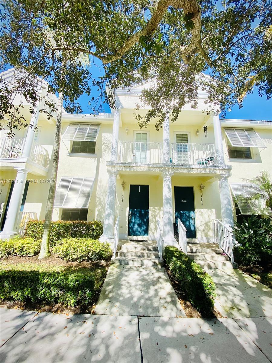 A two-story townhouse exterior features white columns, balconies, and blue front doors — 1557 Frederick Small Rd # 1557, Jupiter FL 33458, JUPITER, FL