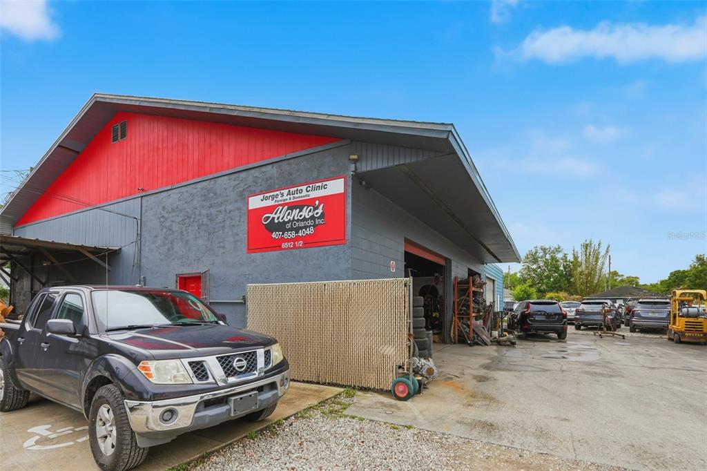 A grey and red auto repair shop building with a parked pickup truck in front — 6512 OLD CHENEY HIGHWAY, ORLANDO, FL