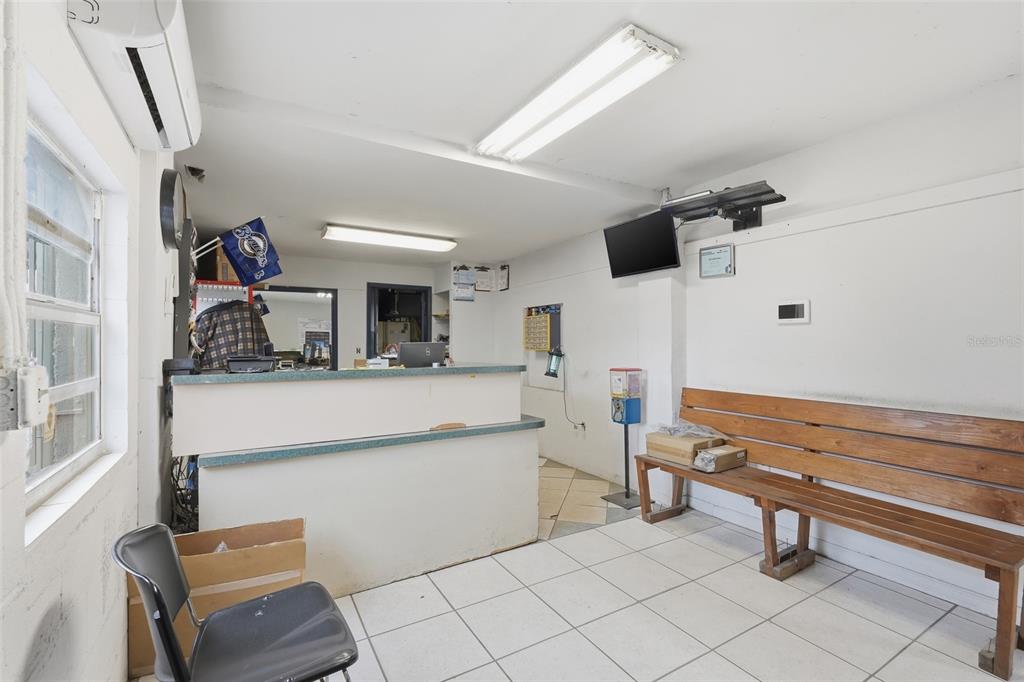 A waiting area features a reception desk, a wooden bench, and white tiled flooring — 6512 OLD CHENEY HIGHWAY, ORLANDO, FL