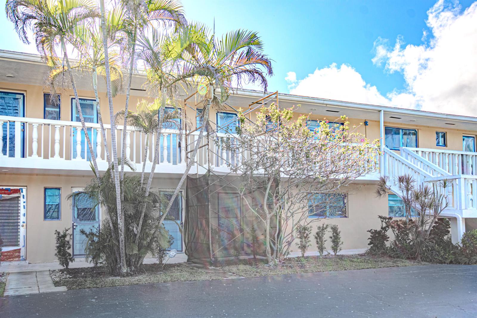 A two-story apartment building with a balcony, exterior staircase, and palm trees in front — 2222 NE 1st Way # 202, Boynton Beach FL 33435, BOYNTON BEACH, FL