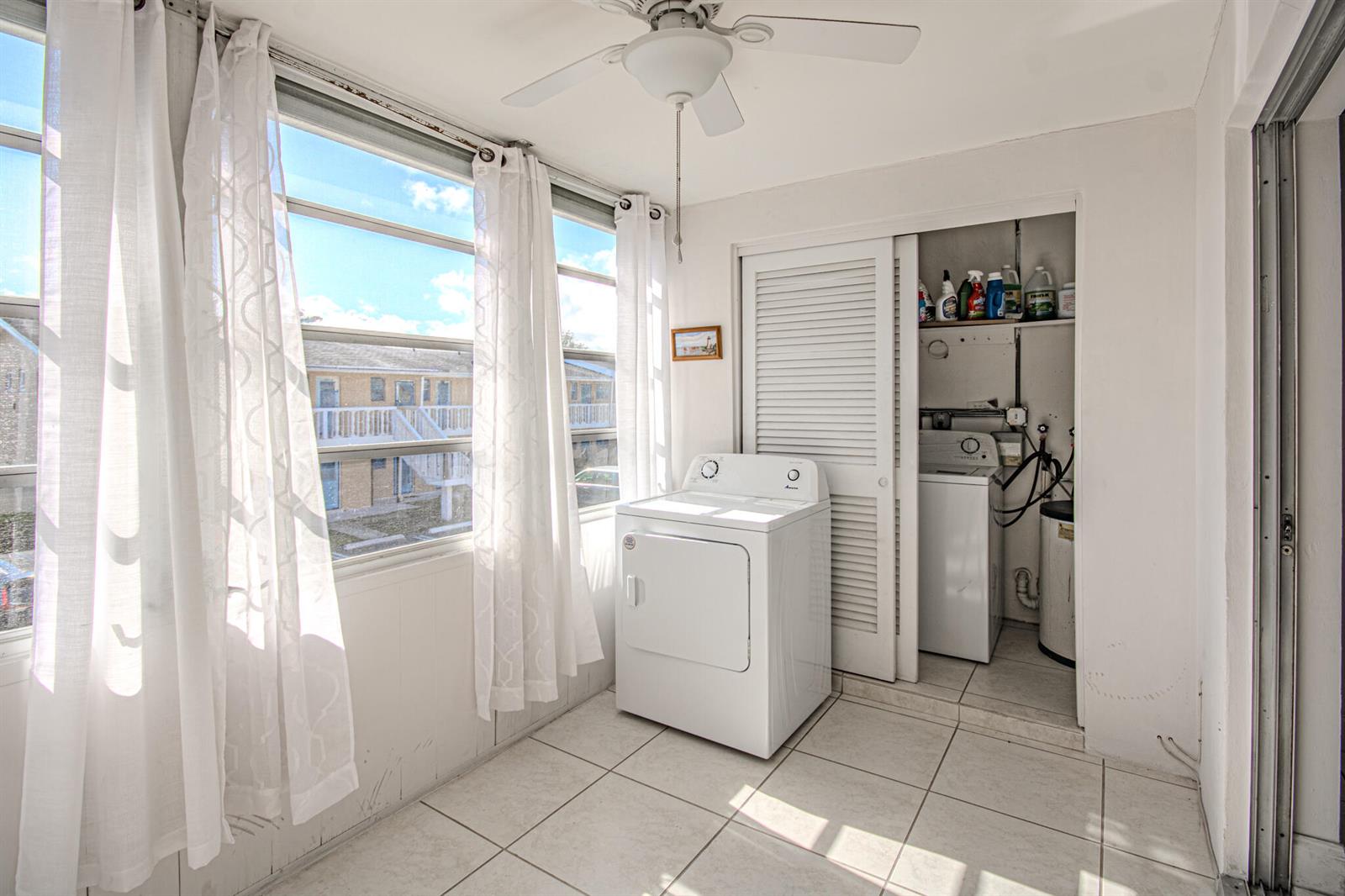 A laundry room with white tile floors, a dryer, and a closet containing a washer — 2222 NE 1st Way # 202, Boynton Beach FL 33435, BOYNTON BEACH, FL