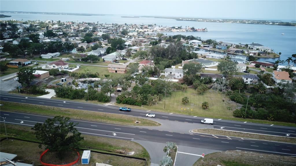 An aerial view shows a multi-lane road passing by a residential neighborhood near the water — 5405 US HIGHWAY 19, PALMETTO, FL