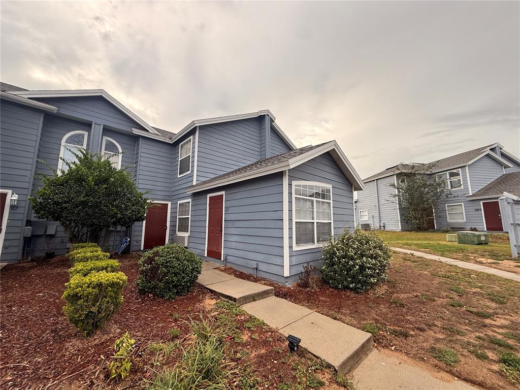 A blue two-story multi-family building with red doors and a concrete walkway — 527 CARIBBEAN DRIVE UNIT B, DAVENPORT, FL