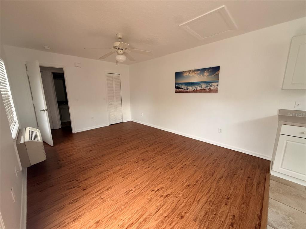 An interior room features wood-look flooring, a ceiling fan, and a wall-mounted air conditioner — 527 CARIBBEAN DRIVE UNIT B, DAVENPORT, FL