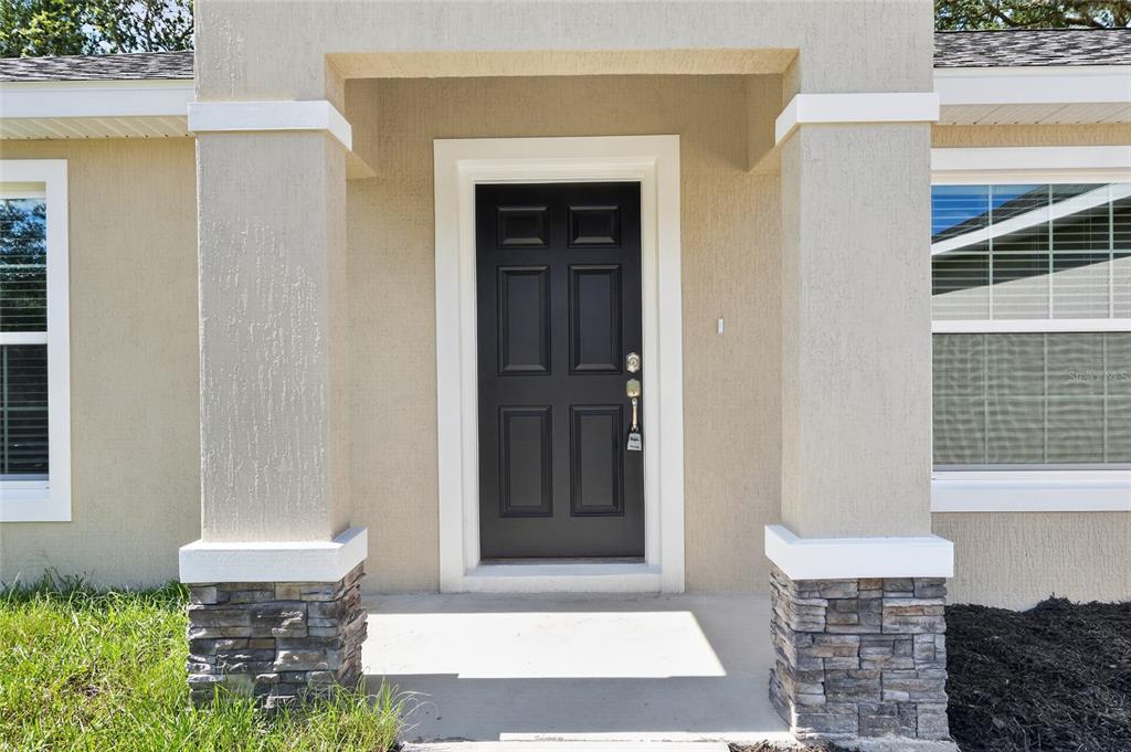 A kitchen with granite countertops and a breakfast bar opens into a living area — 22732 SW MARINE BOULEVARD, DUNNELLON, FL