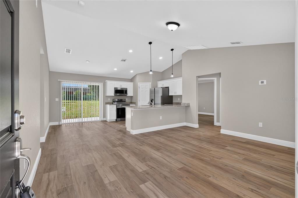 A kitchen with white cabinets, stainless steel appliances, and a sliding glass door to a yard — 22732 SW MARINE BOULEVARD, DUNNELLON, FL