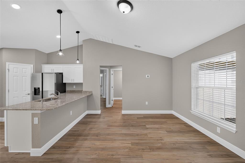 A bathroom features a double vanity with granite countertops, white cabinets, and a glass-enclosed shower — 22732 SW MARINE BOULEVARD, DUNNELLON, FL