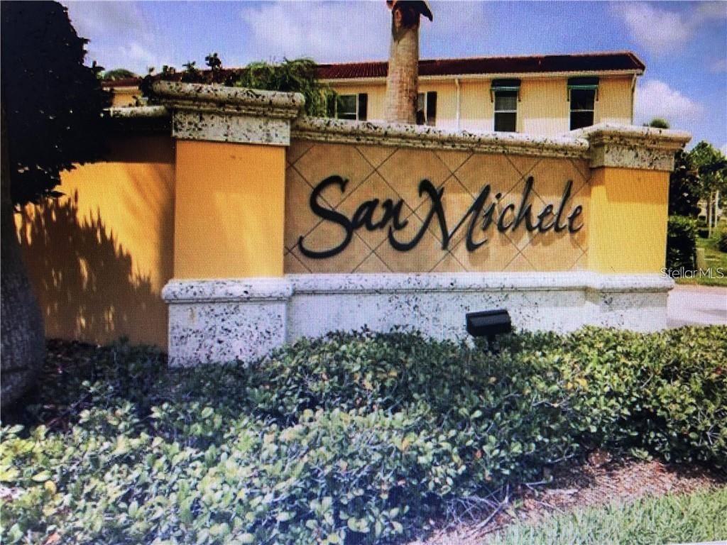 A stucco monument sign for San Michele stands in front of a multi-story residential building — 3770 82ND AVENUE CIRCLE E UNIT 103, SARASOTA, FL