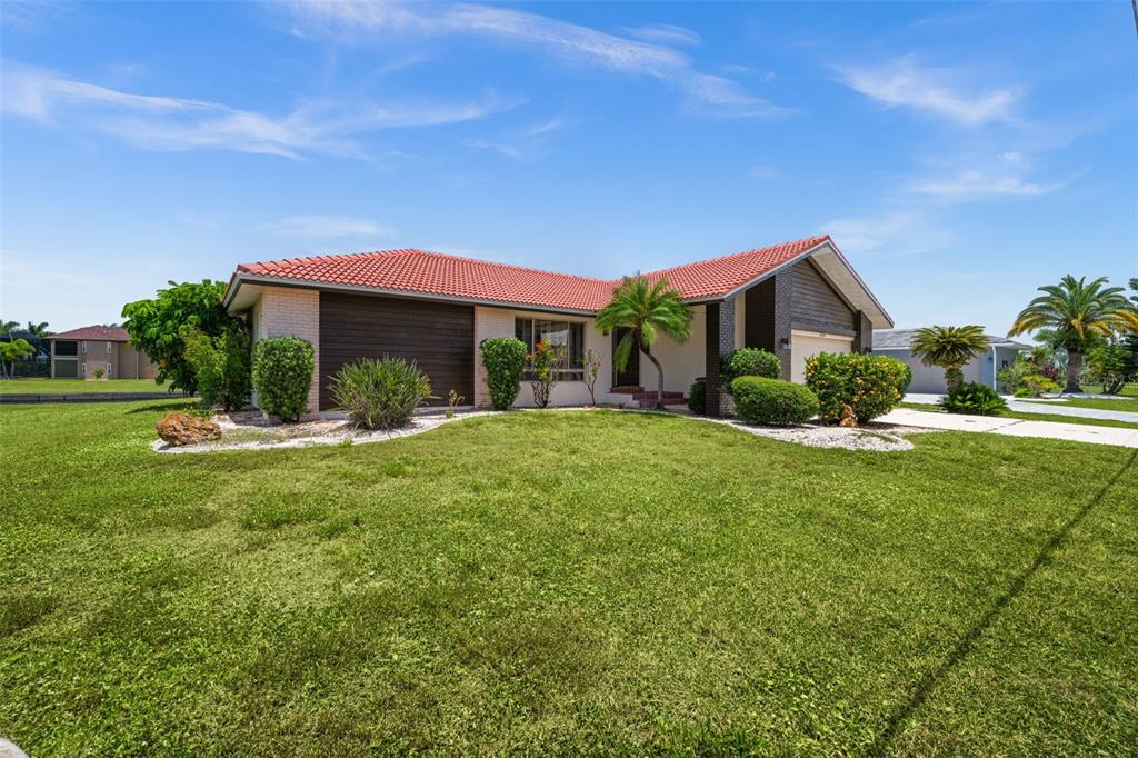 A single-story house with a red tile roof and a large front lawn — 3330 TRIPOLI BOULEVARD, PUNTA GORDA, FL