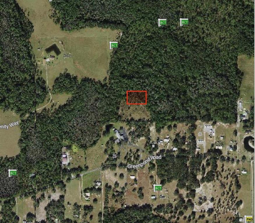 This is an aerial map showing a rectangular property highlighted in red within a wooded area — POLK CITY, POLK CITY, FL