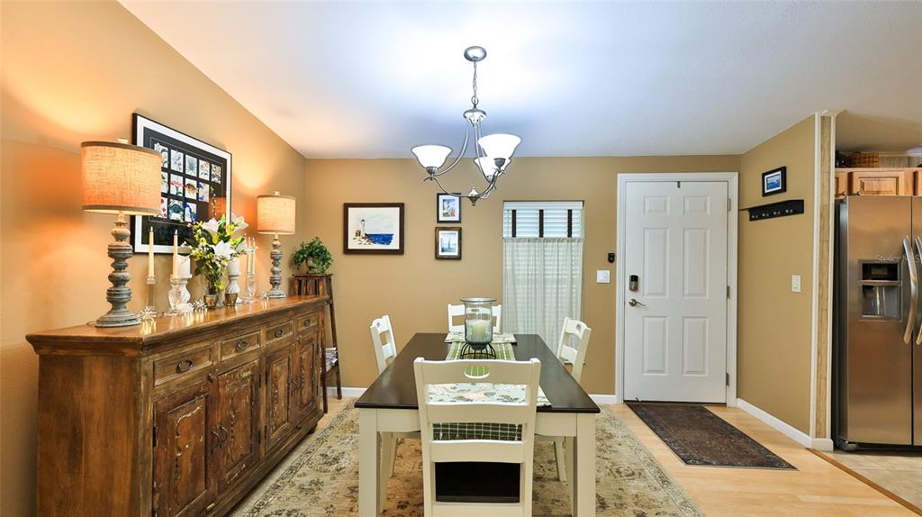 A dining room features a wooden sideboard, a rectangular table with chairs, and a chandelier — 380 MARSH LANDING LOOP, OAK HILL, FL