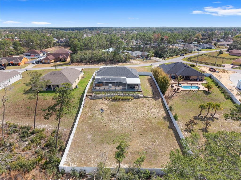 An aerial view shows a residential house with a screened-in patio and a large backyard — 4321 SW 106TH PLACE, OCALA, FL