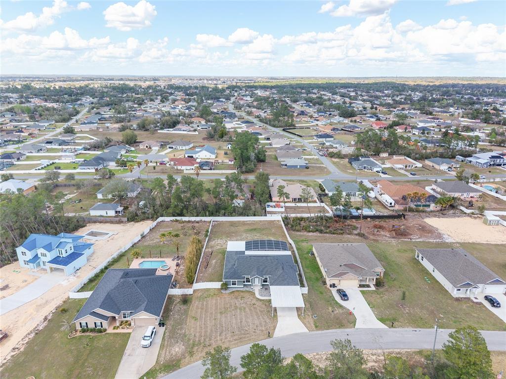 An aerial view shows several suburban houses with fenced yards and pools in a residential neighborhood — 4321 SW 106TH PLACE, OCALA, FL