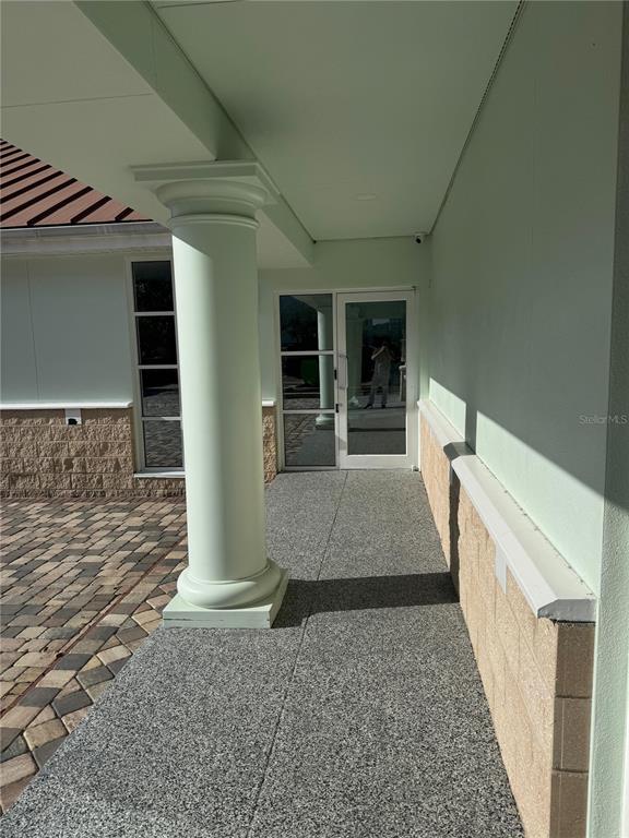 A covered walkway leads to a glass door with a single column and stone accents — 2708 W VIRGINIA AVENUE, TAMPA, FL