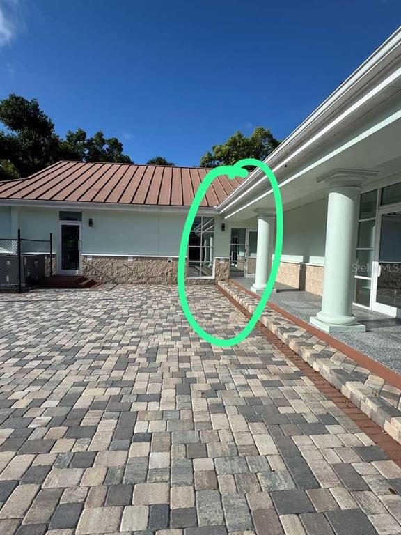 A paved courtyard leads to a building entrance with white columns and glass doors — 2708 W VIRGINIA AVENUE, TAMPA, FL