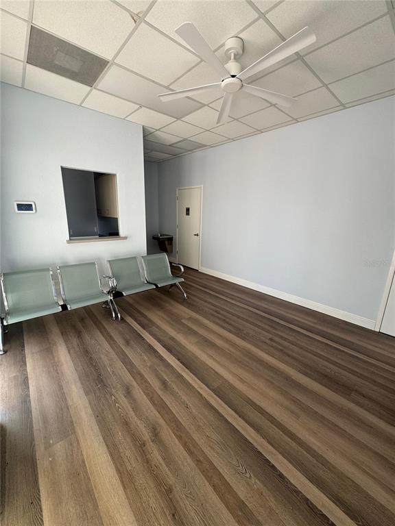 A waiting room features light blue walls, wood-look flooring, a ceiling fan, and metal chairs — 2708 W VIRGINIA AVENUE, TAMPA, FL
