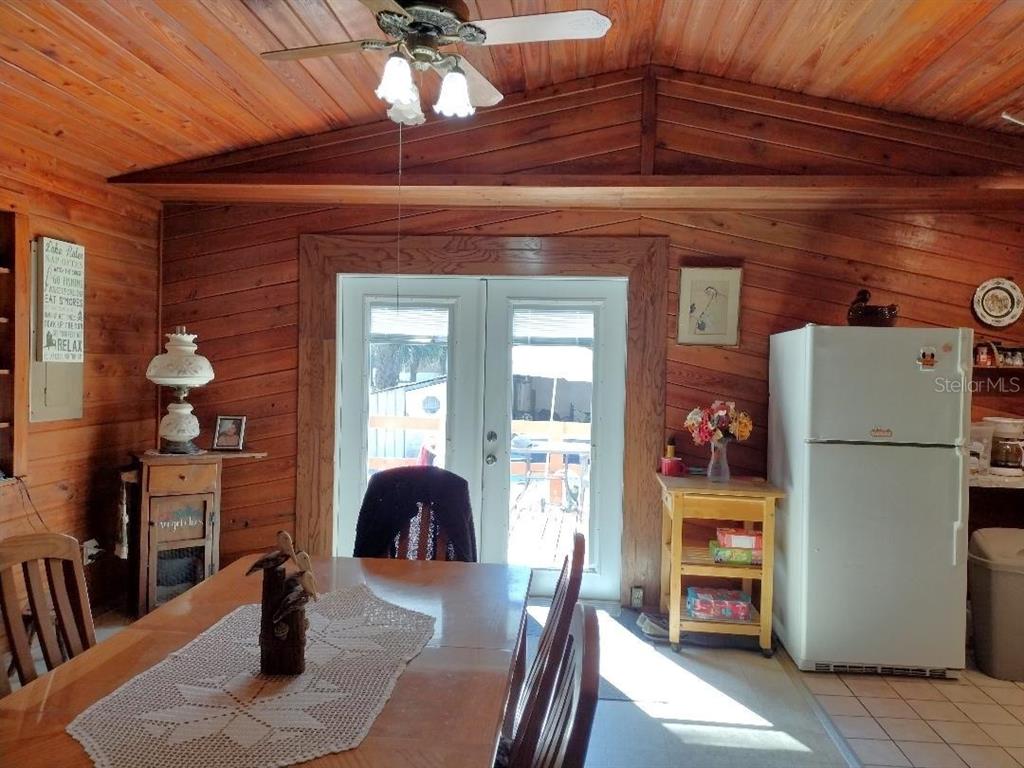 A dining area features wood-paneled walls, a ceiling fan, and a white refrigerator — 1916 LAUREL AVENUE, BUNNELL, FL