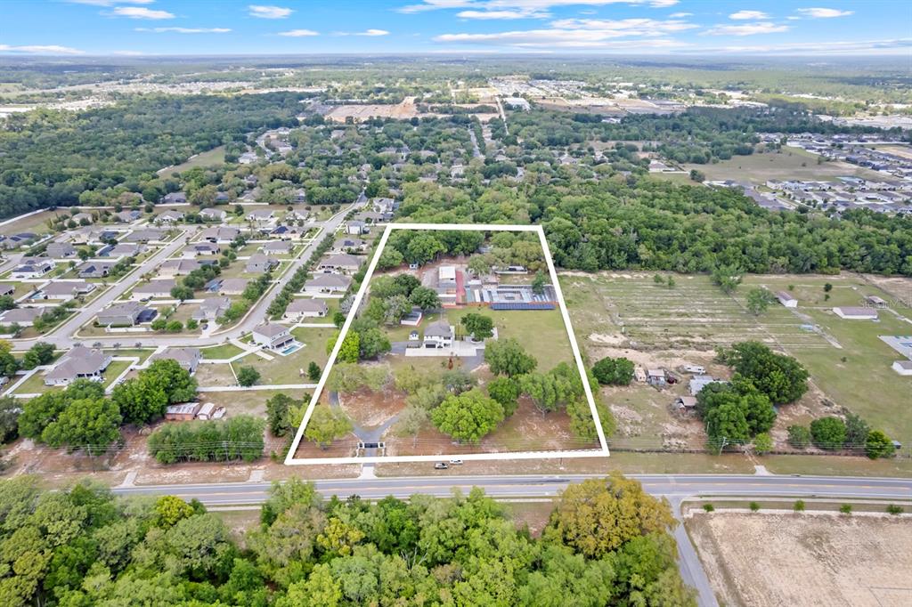 An aerial view shows a house and outbuildings on a large, partially wooded lot — 2509 APPY LANE, APOPKA, FL