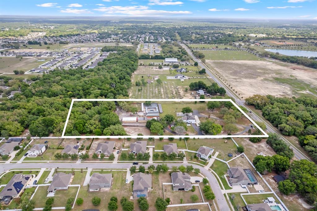 An aerial view shows a large, rectangular property lot outlined in white amidst suburban homes — 2509 APPY LANE, APOPKA, FL