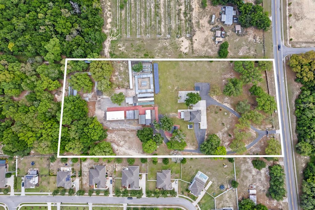 An aerial view shows a large residential property with multiple outbuildings and a paved driveway — 2509 APPY LANE, APOPKA, FL