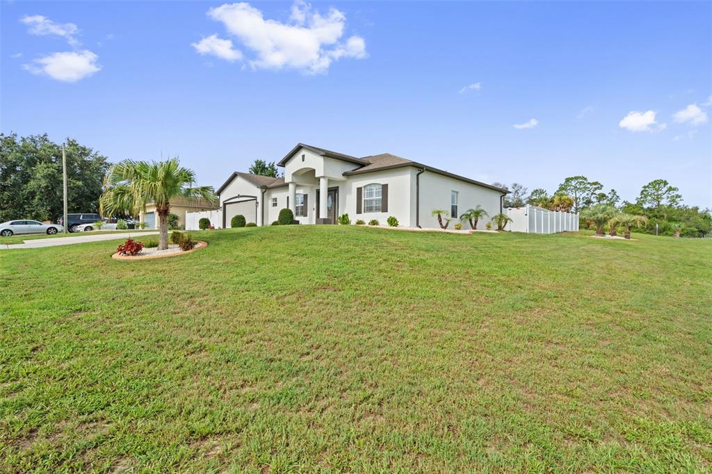 A single-story house with a white exterior and a large grassy front yard — 3059 HOBAN AVENUE, SPRING HILL, FL