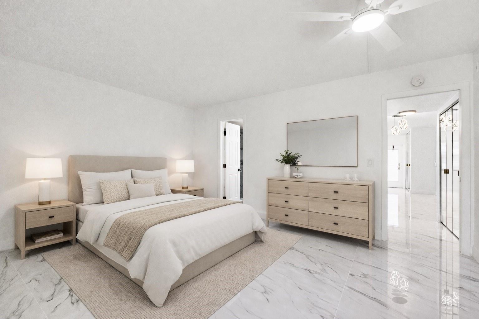 A bedroom with a bed, dresser, and mirror on white marble floors — 242 Tilford L # L, Deerfield Beach FL 33442, DEERFIELD BEACH, FL