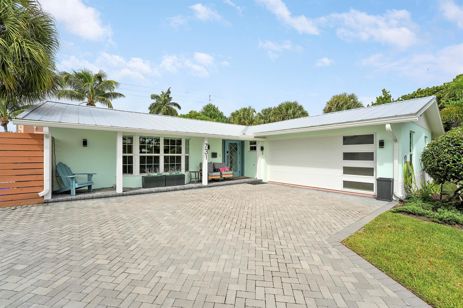 A light green single-story house with a metal roof and a paved driveway — 731 Cruiser Road S, North Palm Beach FL 33408, NORTH PALM BEACH, FL