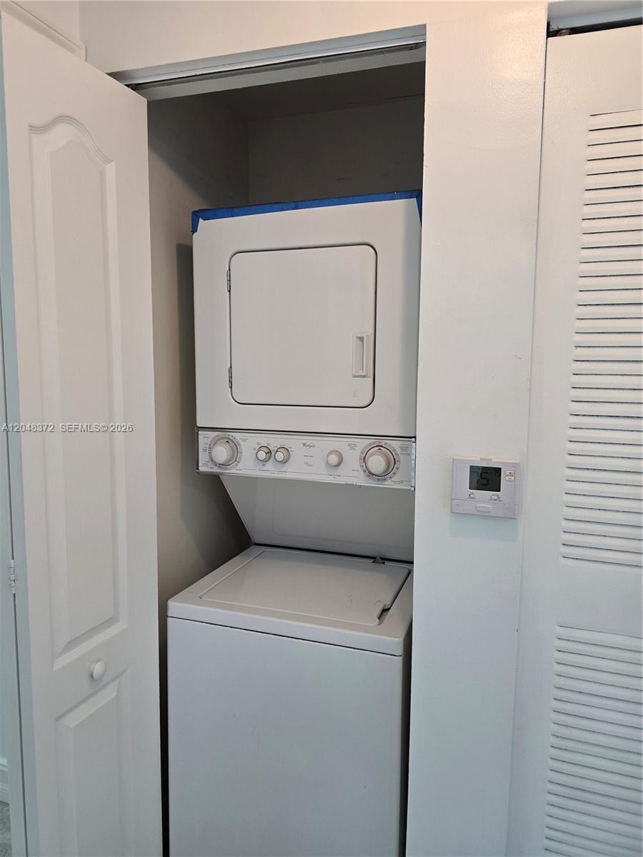A white stacked washer and dryer unit is installed inside a closet — 117 NW 42nd Ave # 503, Miami FL 33126, MIAMI, FL