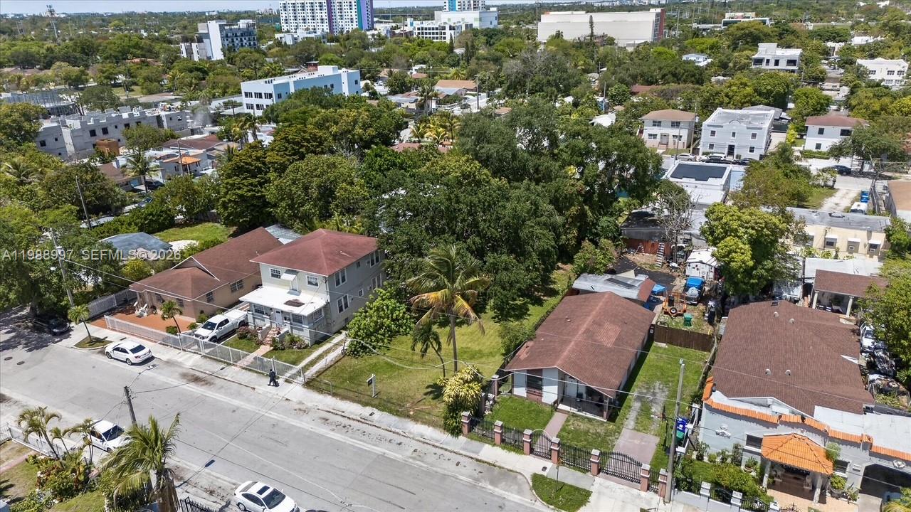 An aerial view shows several houses with brown roofs and a large tree-filled lot — 267 NW 31st St, Miami FL 33127, MIAMI, FL