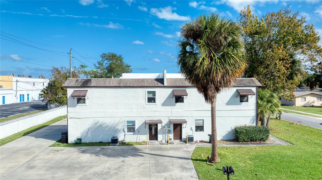 A two-story white stucco building with a palm tree in the front yard — 644 NORTHERN ROAD, SOUTH DAYTONA, FL