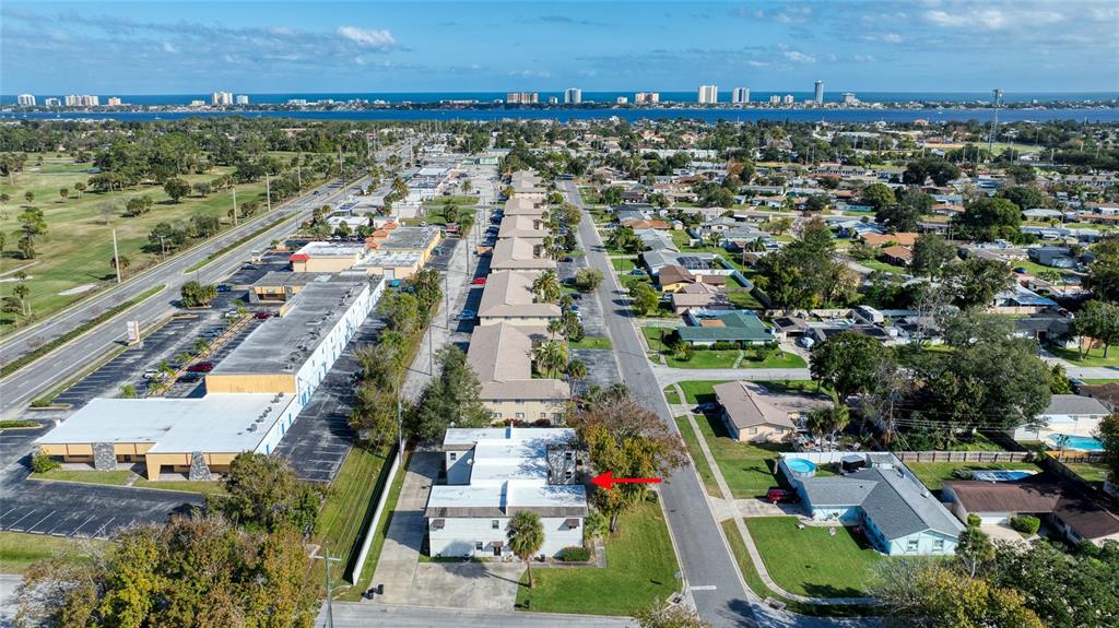 An aerial view shows a multi-unit residential building with a red arrow pointing toward it — 644 NORTHERN ROAD, SOUTH DAYTONA, FL