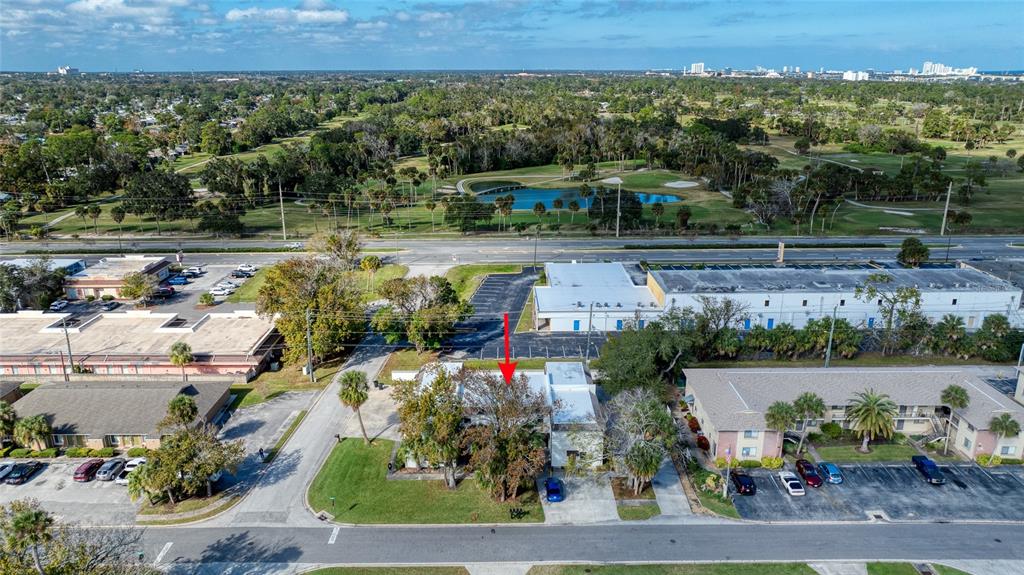 An aerial view shows a commercial building with a red arrow pointing to its roof — 644 NORTHERN ROAD, SOUTH DAYTONA, FL