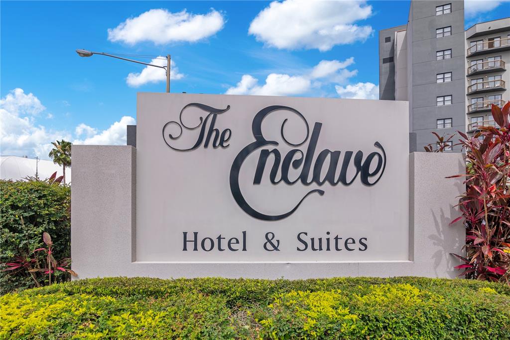 A sign for The Enclave Hotel & Suites stands in front of a multi-story building — 6165 CARRIER DRIVE UNIT 2605, ORLANDO, FL