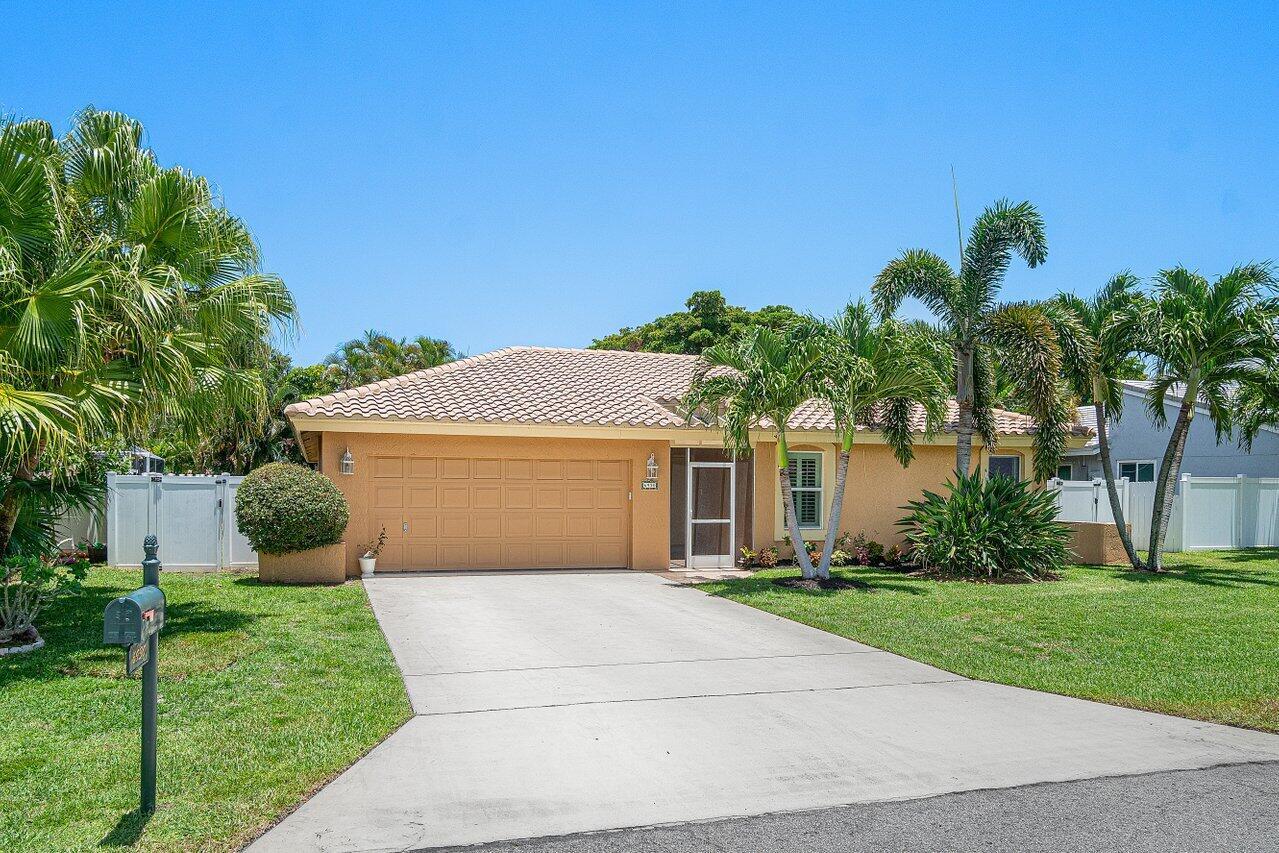 A single-story house with a tan stucco exterior, a two-car garage, and palm trees — 6930 NW 2nd Terrace, Boca Raton FL 33487, BOCA RATON, FL
