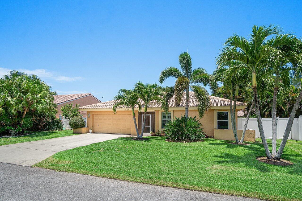 A single-story tan house with a two-car garage and palm trees in the front yard — 6930 NW 2nd Terrace, Boca Raton FL 33487, BOCA RATON, FL