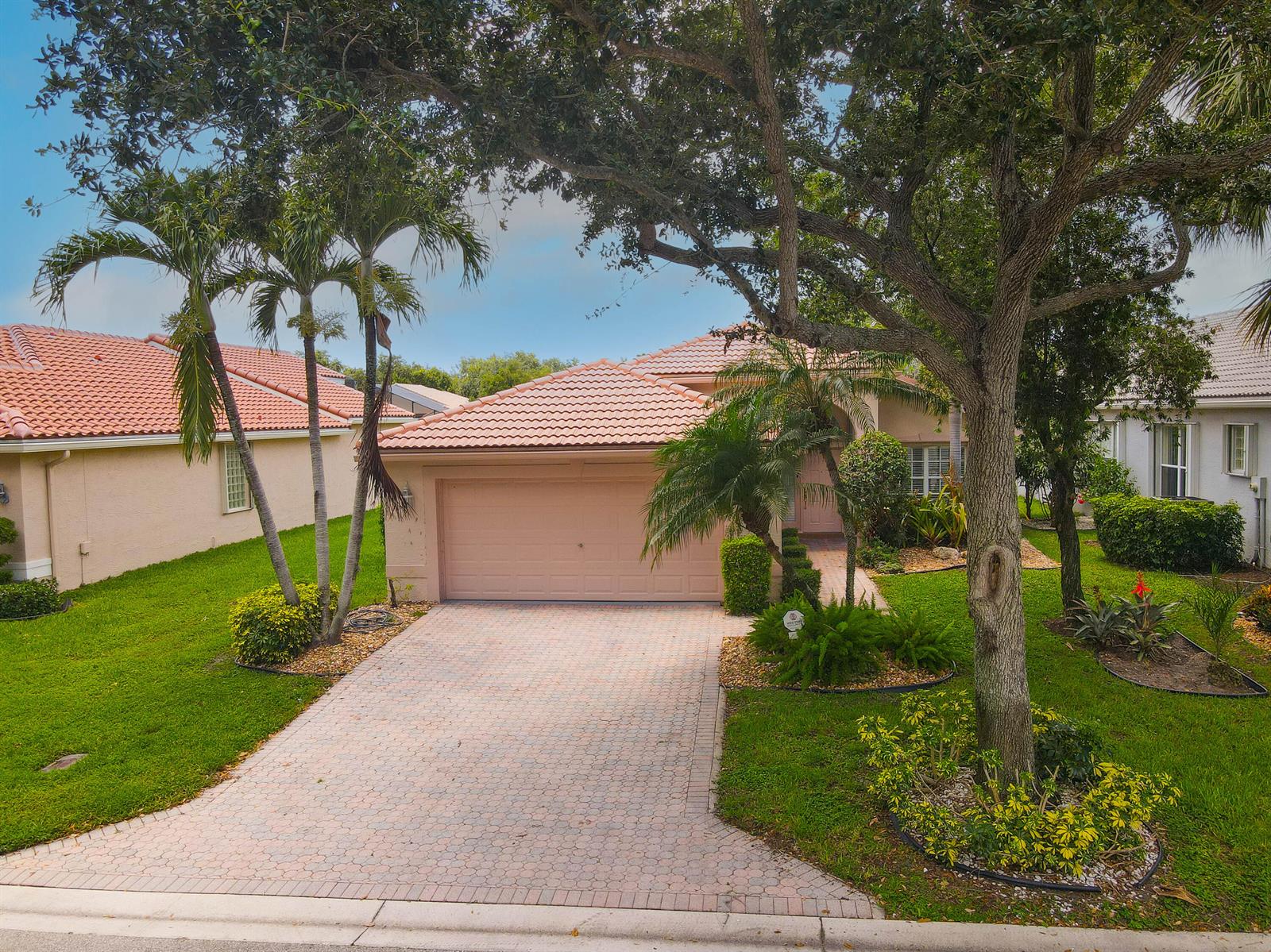 A single-story house with a tiled roof, a paved driveway, and mature trees in front — 7387 Tonga Court, Boynton Beach FL 33437, BOYNTON BEACH, FL