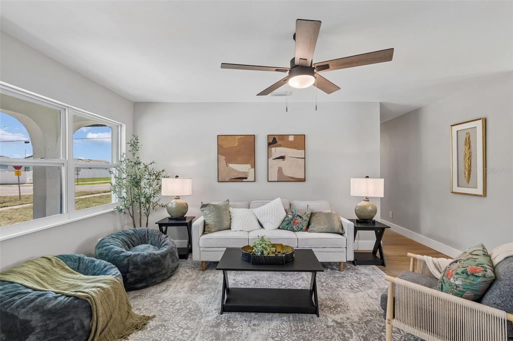 A living room features a sofa, two beanbag chairs, a coffee table, and a ceiling fan — 5802 12TH AVENUE S, TAMPA, FL