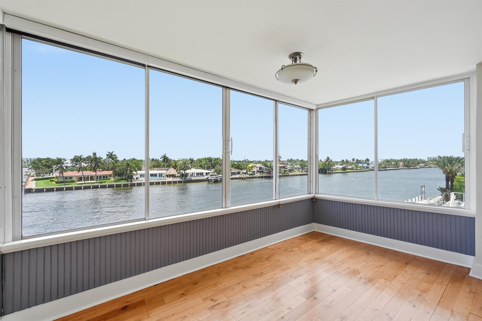 An aerial view of a waterfront apartment building with a pool deck along a canal — 401 N Riverside Drive # 408, Pompano Beach FL 33062, POMPANO BEACH, FL