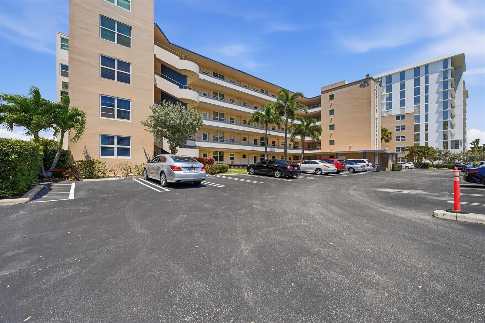A kitchen with wood cabinets, granite countertops, and an island, adjacent to an open living area — 401 N Riverside Drive # 408, Pompano Beach FL 33062, POMPANO BEACH, FL