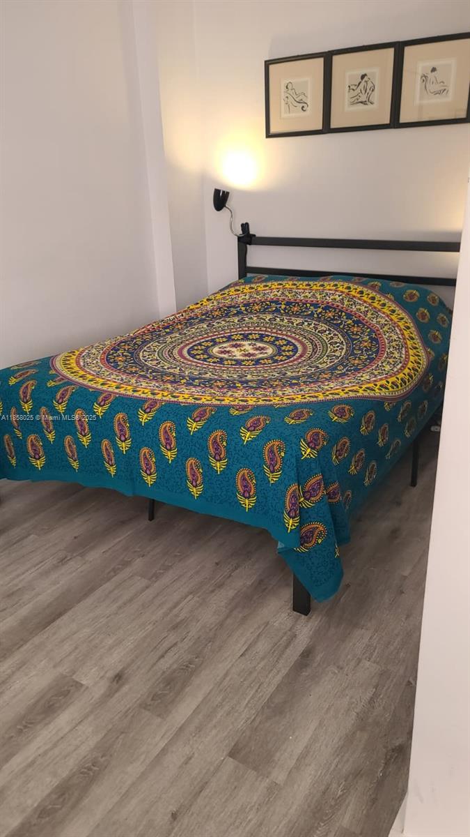 A bedroom features a bed with a colorful patterned spread and three framed wall pictures — 3710 Collins Ave # 309, Miami Beach FL 33140, MIAMI BEACH, FL