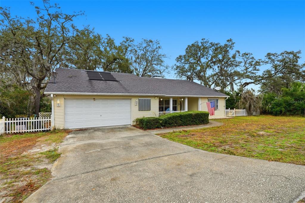 A single-story house with yellow siding, a two-car garage, and a front porch — 12227 TERRA CEIA AVENUE, NEW PORT RICHEY, FL