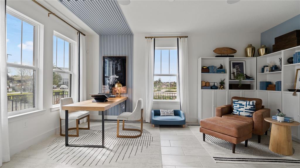 A home office features a wood desk, a leather armchair with ottoman, and blue-accented shelving — 15075 GROVESIDE ROAD, WINTER GARDEN, FL