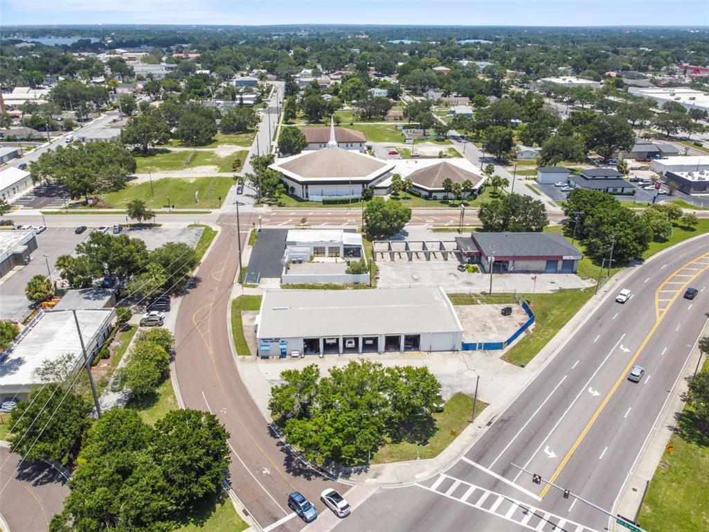 An aerial view shows a commercial property with a large warehouse and adjacent parking lots — 304 AVENUE E SW, WINTER HAVEN, FL