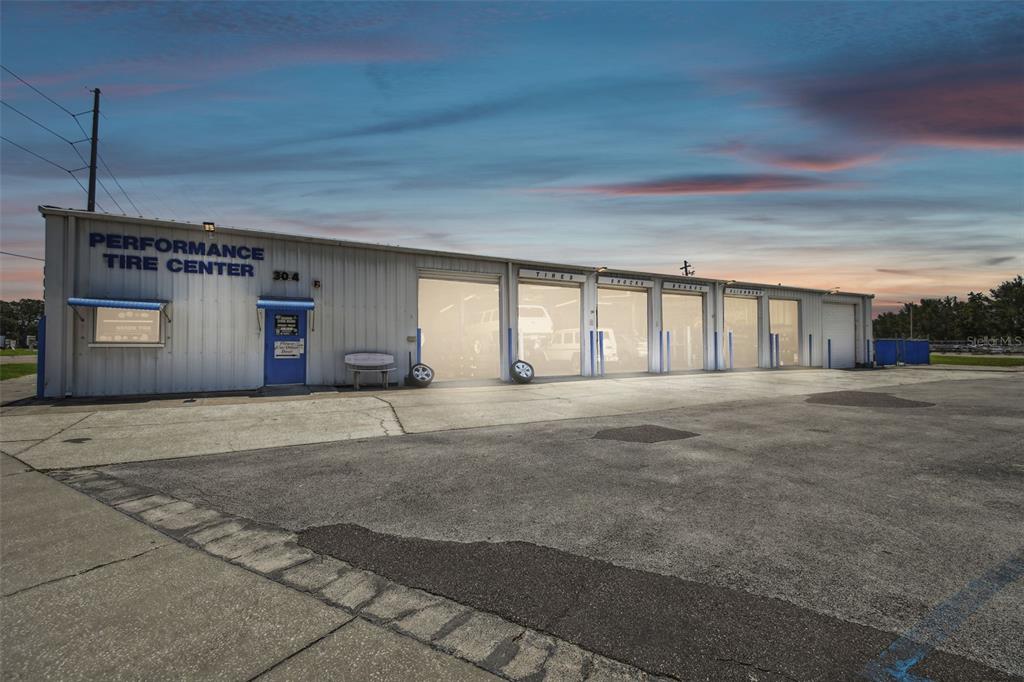 An exterior view of a single-story commercial building with multiple service bays for automotive repair — 304 AVENUE E SW, WINTER HAVEN, FL