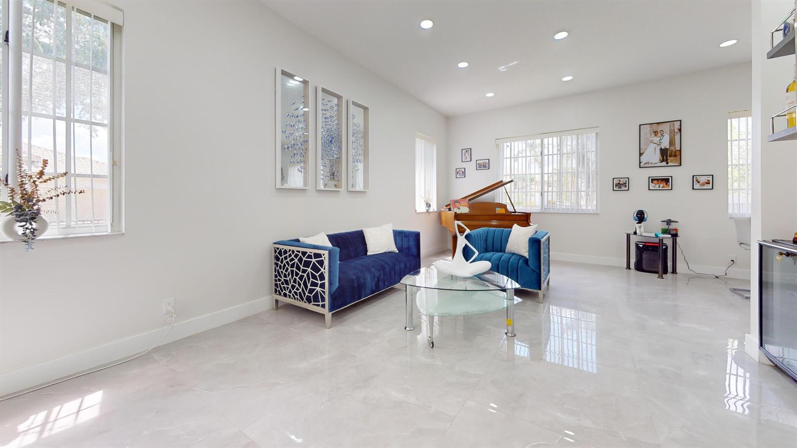 A living room features blue velvet sofas, a glass coffee table, and a grand piano — 8586 White Cay, West Palm Beach FL 33411, WEST PALM BEACH, FL