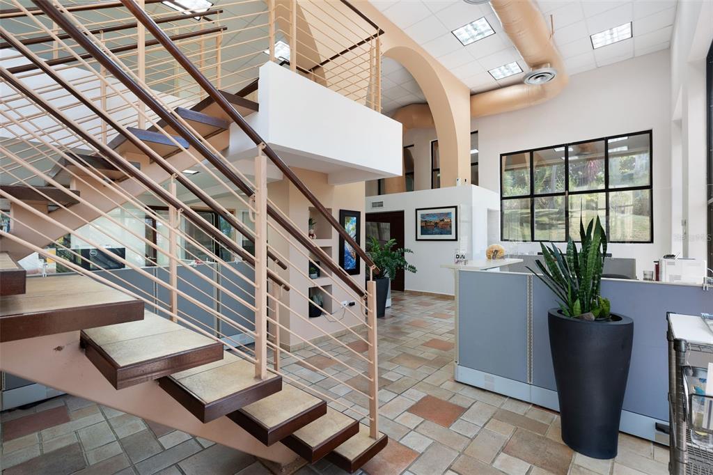 An office interior features a staircase with metal railings, tile flooring, and a large plant — 295 PALMAS INN WAY UNIT C11, HUMACAO, PR
