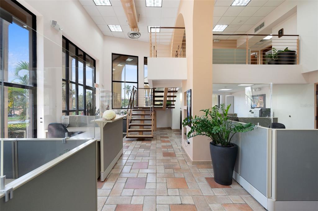 A bright office lobby features a tiled floor, a central staircase, and a mezzanine level — 295 PALMAS INN WAY UNIT C11, HUMACAO, PR